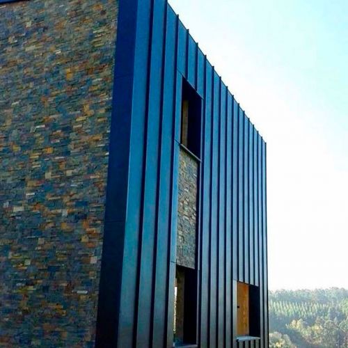 Edificio con detalles de fachada en antracita